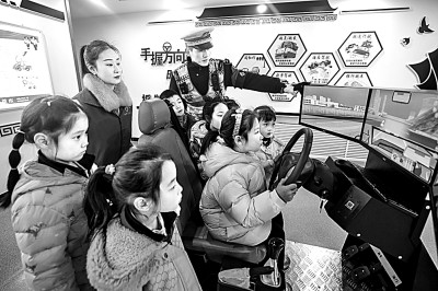 山東省榮成市公安局道路交通安全宣傳教育基地，交警帶領(lǐng)小學(xué)生現(xiàn)場體驗?zāi)M駕駛。新華社發(fā)